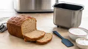 Oppskåret glutenfritt brød ved ren bakeform, egen slikkepott, mel og stivelse